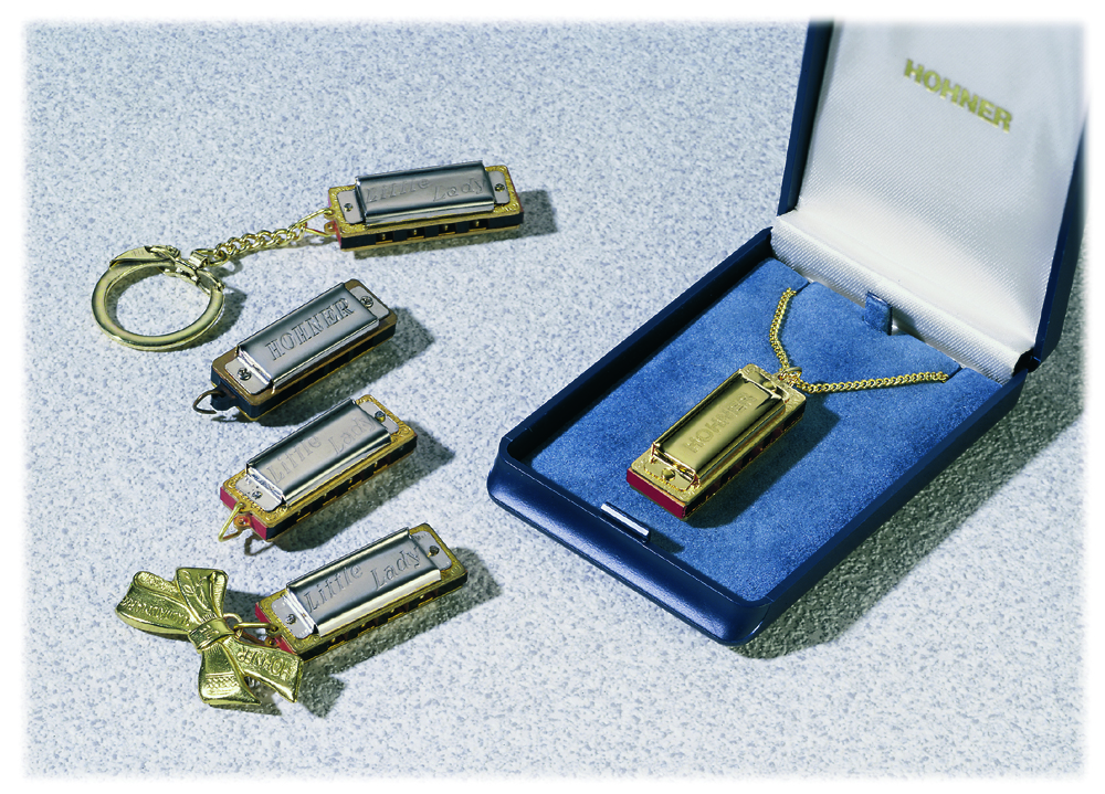 Several tiny Hohner Little Lady harmonicas, one in a blue presentation box