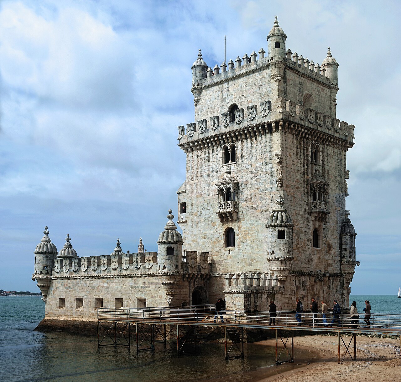 A carved white stone tower on the edge of the river