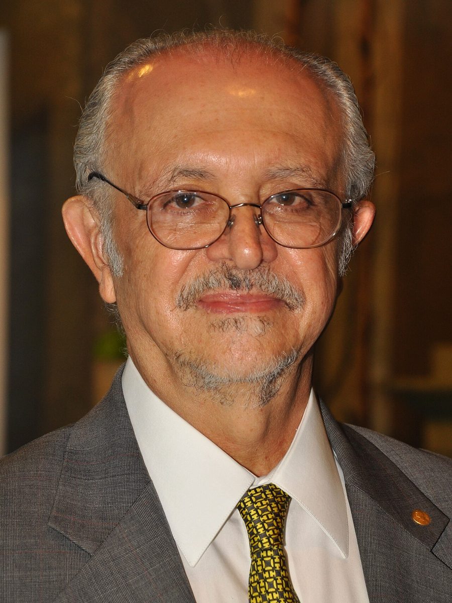 Mario Molina, an older man with glasses and a gray mustache, in a suit and tie