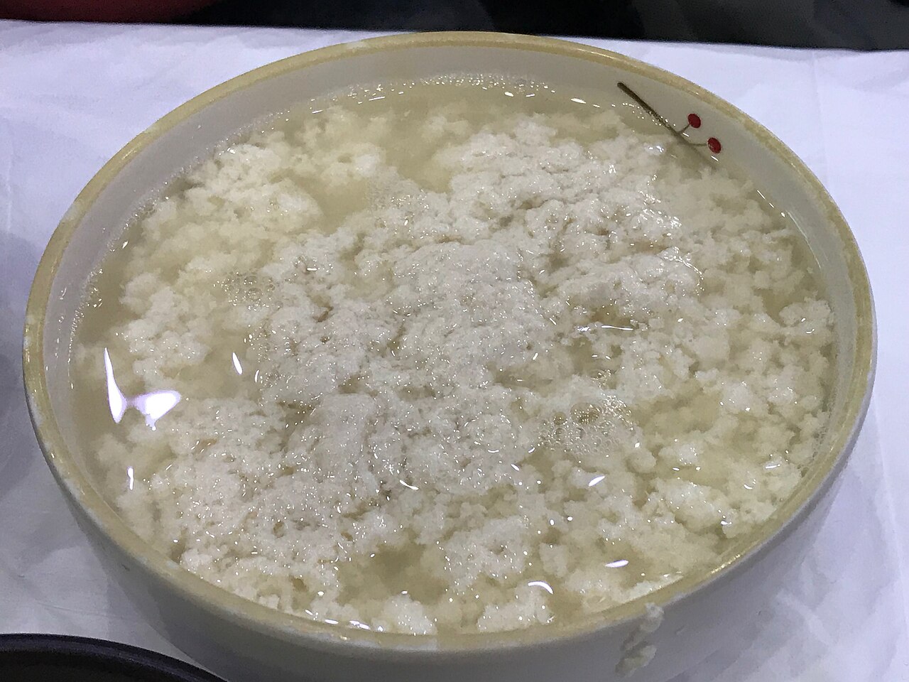 A large bowl of fresh white tofu curds floating in their liquid